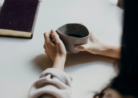 Woman sitting quietly with a coffee, reflecting